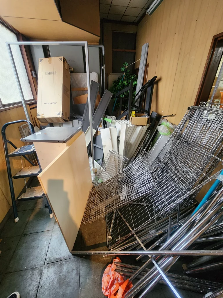 倉庫内に散乱した金属棚やパネル部品の廃棄状況