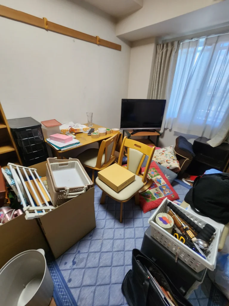 整理中の家具や生活用品が散らかった室内の様子