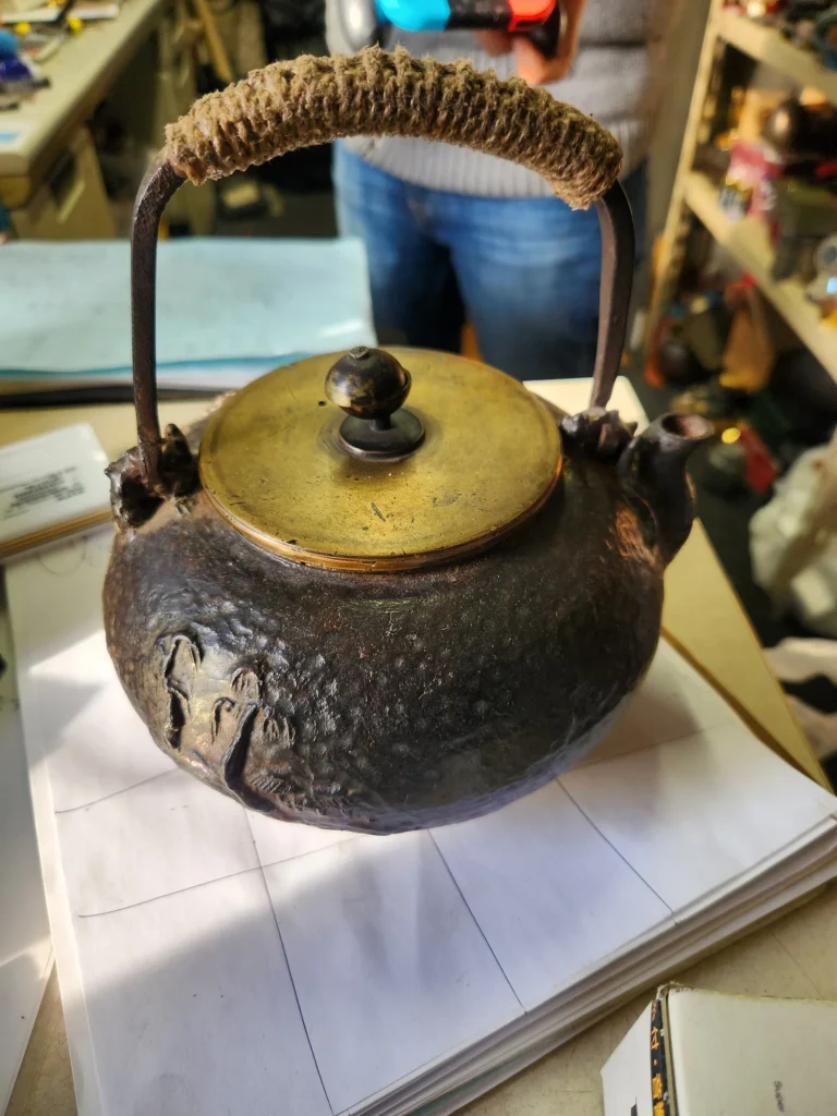 古びた金属製の茶瓶と麻縄巻きの取っ手